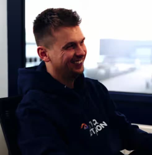 Lachende marketeer in hoodie bij kantoorvenster
