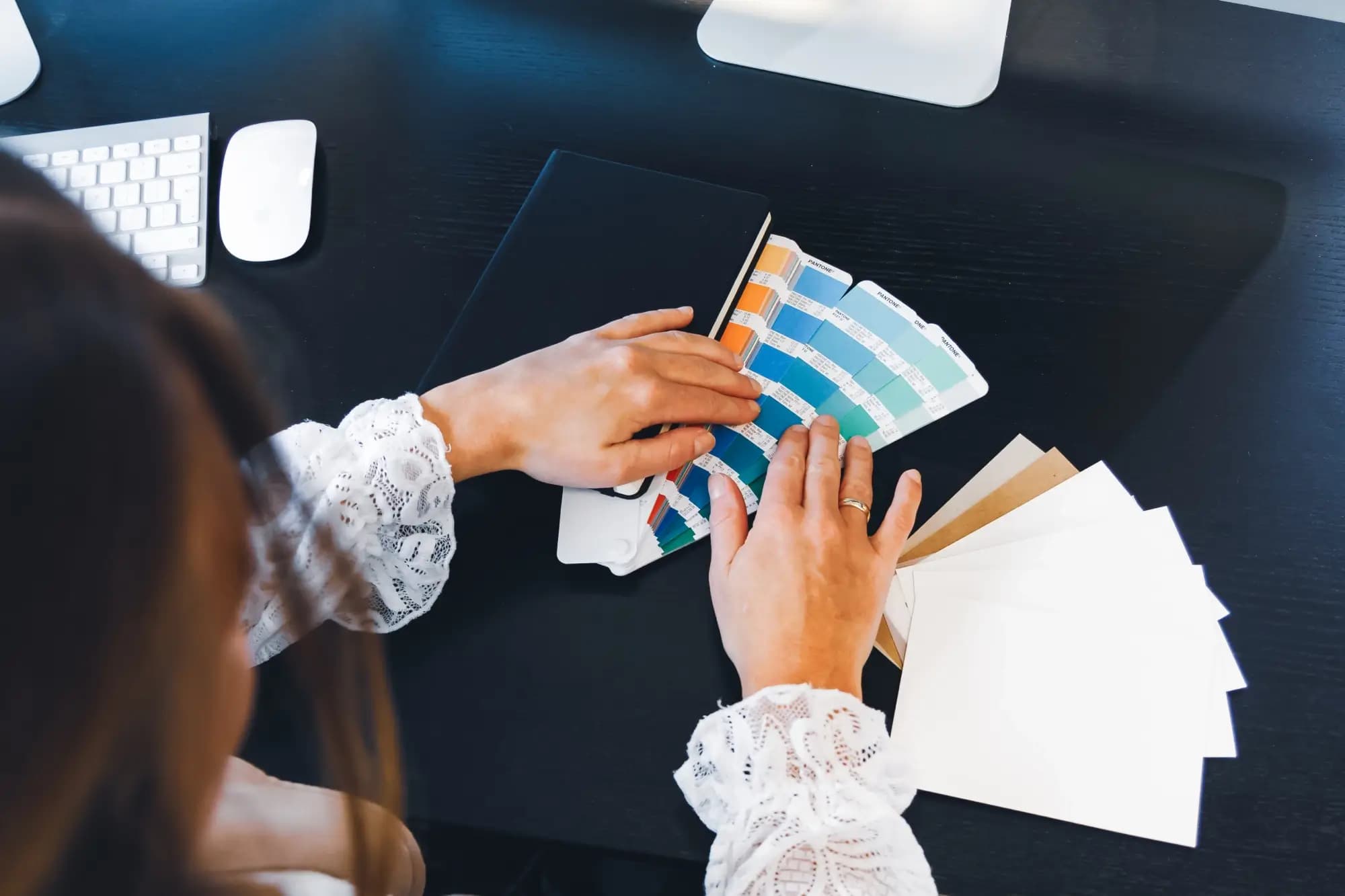 Designer bekijkt Pantone kleurenstalen voor merkidentiteit